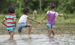 Indian kids wade through flood waters as flash flood hit the region at Naharkatia, about 4...