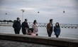 People wearing protective masks perform activities in the vicinity of the Tejo river boule...