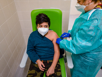 A boy gets the vaccine injected by a nurse during the night dedicated to 12-19 year olds at the Cozzoli vaccination hub in Molfetta on Janua...