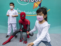 A student poses with a spiderman character after being vaccinated in South Tangerang, Banten, Indonesia on 17 January 2022. Indonesia is pre...