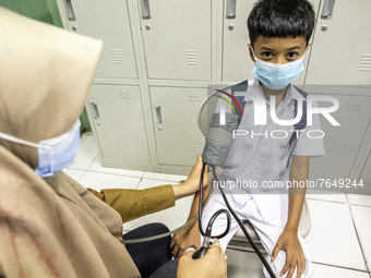 A student has his blood pressure checked before receiving the COVID-19 vaccine in South Tangerang, Banten, Indonesia on 17 January 2022. Ind...