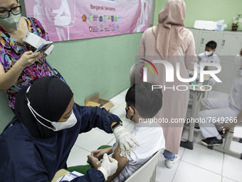 A mother records the process of her child's covid-19 vaccine in South Tangerang, Banten, Indonesia on 17 January 2022. Indonesia is preparin...