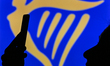An image of a woman holding a cell phone in front of the Ryanair logo displayed on a compu...