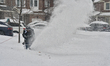 Man uses a snow blower to clear the snow in front of his home as a massive snowstorm hit T...