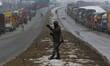An Indian Army soldier reacts as Trucks are parked on Sringar-Jammu Highway in South Kashm...