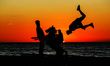 A Palestinian youth practice his parkour skills in the beach of Gaza City during Sunset, o...