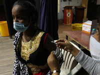 A health worker inoculates a college student with a dose of Covaxin vaccine against the Covid-19 coronavirus during a vaccination drive for...
