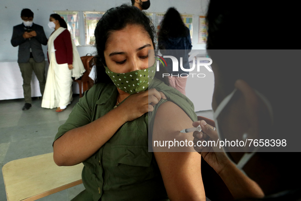A health worker inoculates a School student with a dose of the Covaxin vaccine against the Covid-19 coronavirus during a vaccination drive f...