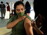 A health worker inoculates a School student with a dose of the Covaxin vaccine against the Covid-19 coronavirus during a vaccination drive f...