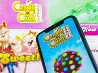 Candy Crush Saga logo displayed on a phone screen and Candy Crush website displayed in the background is seen in this illustration photo tak...