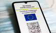 EU Digital COVID Certificate is displayed on a mobile phone screen photographed on surgica...