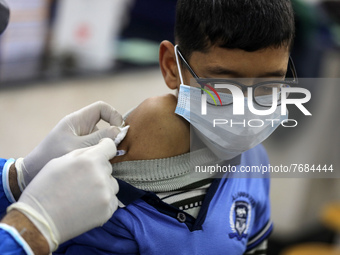 A Palestinian student of the UN Relief and Works Agency (UNRWA) receives a dose of the Pfizer-BioNTech vaccine against COVID-19 during a vac...