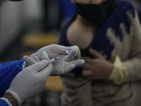 A Palestinian medic prepares a dose of the Pfizer-BioNTech vaccine against COVID-19 during a vaccination campaign at a school of the UN Reli...
