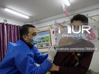 A Palestinian student of the UN Relief and Works Agency (UNRWA) receives a dose of the Pfizer-BioNTech vaccine against COVID-19 during a vac...