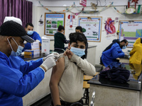 Palestinian students of the UN Relief and Works Agency (UNRWA) receive a dose of the Pfizer-BioNTech vaccine against COVID-19 during a vacci...