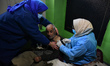 A health worker administers a dose of Covid-19 vaccination booster inside a residential ho...