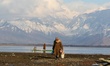 A Kashmiri elderly man walks back after catching Fish at the Wular Lake Amid COVID-19 Coro...