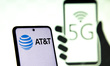 Photo illustration of a mobile phone screen with AT&T logo and 5G signal symbol displayed...