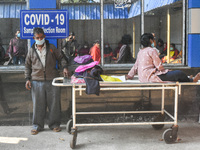 A patient is seen waiting outside a COVID-19 testing center in Kolkata , India , on 31 January 2022 .India recorded over 2 Lakh cases yester...