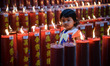 A girl is seen among candles during the Lunar New Year eve, the Year of the Tiger at a tem...