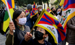 Tibetans hold flags and placards as they march towards Chinese embassy during a protest ag...