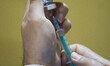 An Iranian health personnel loads a syringe with the South Korea AstraZeneca new coronavir...