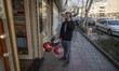 An Iranian man speaks on his smartphone as he holds red balloons while Valentine’s Day sho...