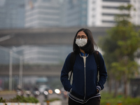 Woman wear protective face masks walk in business district in Jakarta on February 14, 2022. The Minister of Manpower, Ida Fauziyah, stipulat...