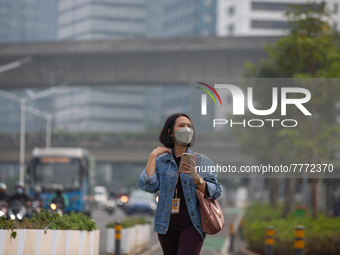 Woman wear protective face masks walk in business district in Jakarta on February 14, 2022. The Minister of Manpower, Ida Fauziyah, stipulat...