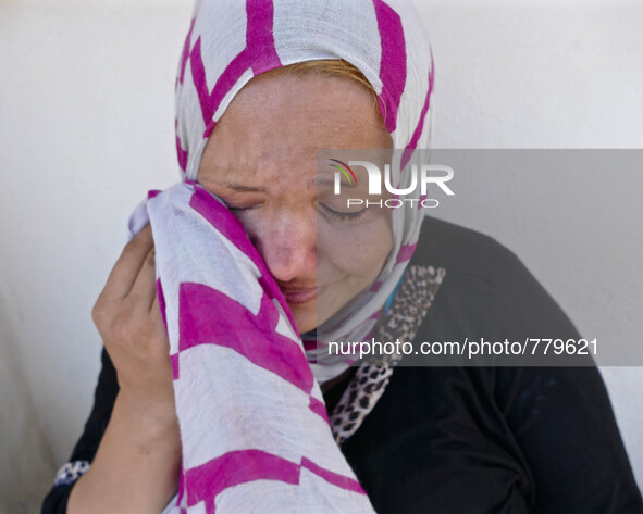 A very tired Syrian women weeps as she sits near the police station on the Greek island of Kos waiting for her documents to be processed to...