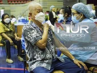 People receive doses of the Pfizer COVID-19 vaccine at a vaccination center inside a stadium in Bangkok, Thailand, 24 February 2022. (