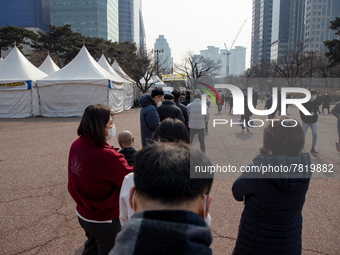 People wait for COVID-19 test at a temporary testing site in Yeouido finance and investment banking district on February 25, 2022 in Seoul,...