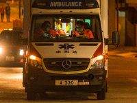 Paramedics in an ambulance in front of the Caritas Medical Centre change their masks inside the ambulance, in Hong Kong, China, on February...