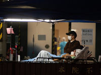 A father stands next to his wife and their child  outside the Accident & Emergency ward of Caritas Medical Centre, in Hong Kong, China, on F...