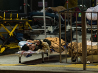 A COVID patient is placed on a stretcher left on the floor outside the Caritas Medical Centre in Sham Shui Po, in Hong Kong, China, on Febru...