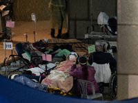 COVID patients sit outside the Accident and Emergency Ward at the Caritas Medical Centre, in Hong Kong, China, on February 25, 2022. (