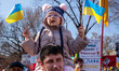 A young protester is one of many to get a seat above the crowd during a rally at the White...