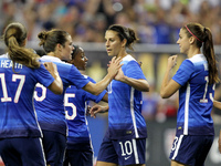 US midfielder Carli Lloyd (10) is congratulated by teammates after scoring a goal on a penalty kick at 37 minutes in the International Frien...