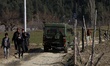 Kashmiri boys walk as An Indian Army Vehicles moves through a far-flung area in Kupwara Ja...