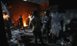 Workers prepare to pour molten iron into a mold to make a propeller at a workshop on the b...