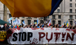 Protesters stand behind a lage banner saying 'stop Putin' outside Downing street in London...