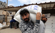 A Palestinian collects food aid at a distribution center run by the United Nations Relief...