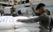 Palestinians collect food aid at a distribution center run by the United Nations Relief an...