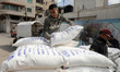 Palestinians collect food aid at a distribution center run by the United Nations Relief an...