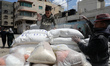 Palestinians collect food aid at a distribution center run by the United Nations Relief an...