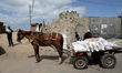 Palestinians collect food aid at a distribution center run by the United Nations Relief an...