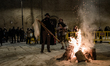 Zampognani play typical songs in front of the bonfire in front of the Mother Church in Noi...