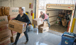 Volunteers with the Ukrainian-American Crisis Response Committee unload deliveries of supp...