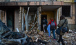 People walk inside a residential building in Sviatoshynskyi district affected by the shell...