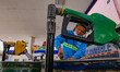 A worker pumps fuel into multiple barrels at a gas station in Mandaluyong City, east of Ma...